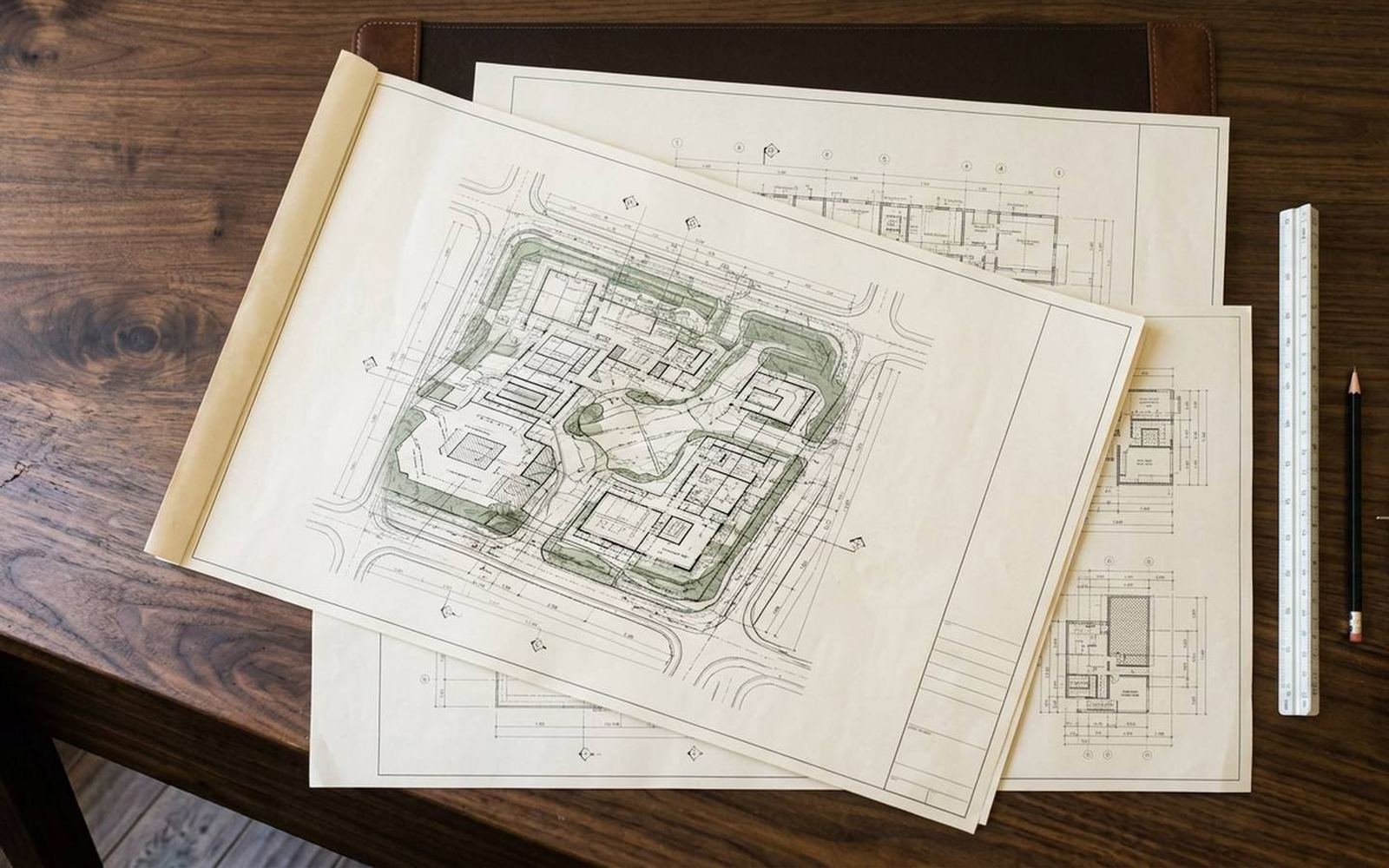 Architectural site layout drawings on a drafting desk